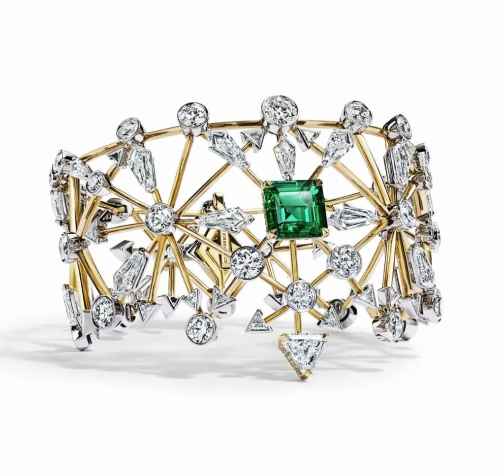 The Arrow gold bracelet by Tiffany is crafted from platinum and yellow gold. It showcases a centerpiece emerald of over 2 carats, cut in the Asscher style. This emerald, certified to be of Colombian origin, has not undergone any oil treatment. The piece is further adorned with diamonds.