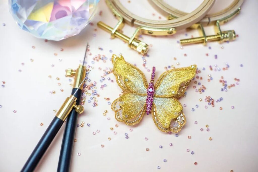 La broderie's embroidered butterfly brooch, set with colored gemstones.