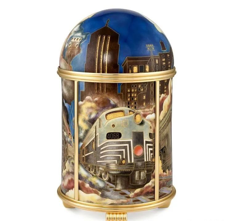 An American railroad dome clock captures the dawn of the U.S. railway era. Striking streamlined trains and New York skyscrapers are recreated in several magnificent cloisonné enamel and silver pavilions.