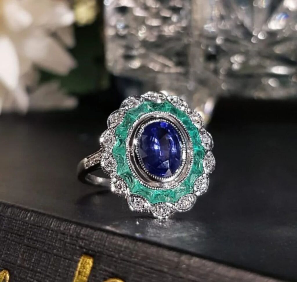 An exquisite oval Ceylon sapphire ring with emerald and diamond pave