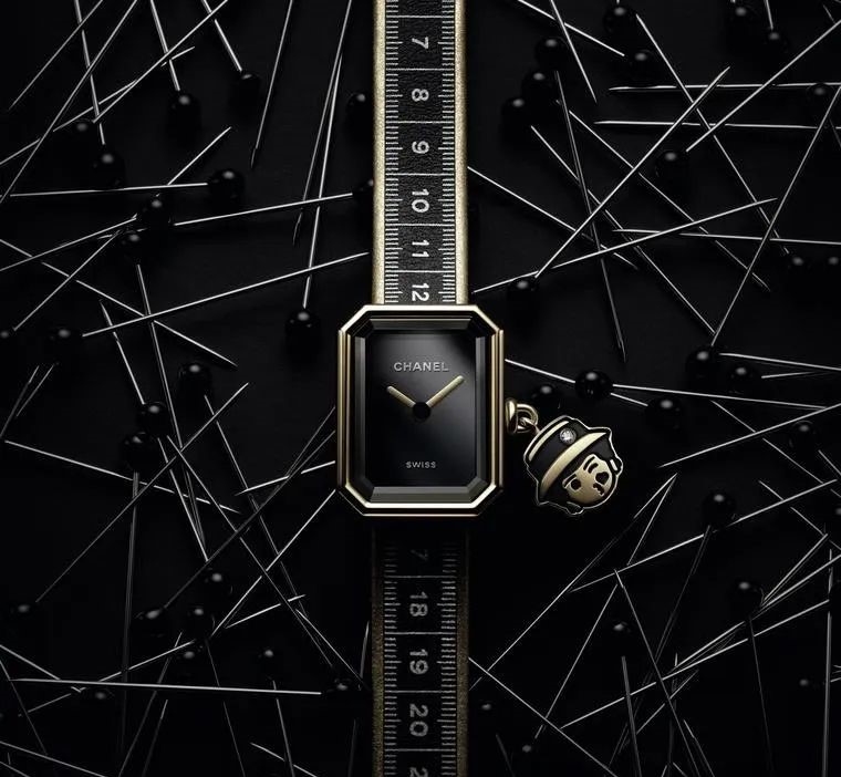 The Chanel Haute Couture Première Ruban watch features a measuring tape pattern printed on its black and gold double-wrap leather strap.