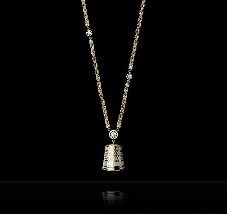 This substantial thimble, hanging from a long gold chain, is set with diamonds and features a dial on its base, limited to 20 pieces.