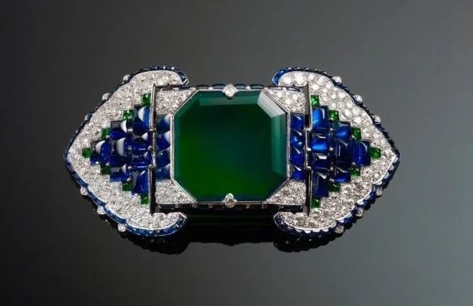 Cartier Art Deco style belt buckle brooch, set with a 38.71-carat emerald, diamonds, and sapphires