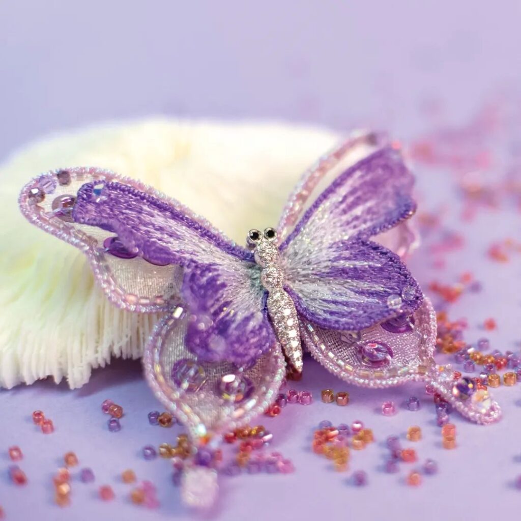 La broderie's embroidered butterfly brooch, set with colored gemstones.