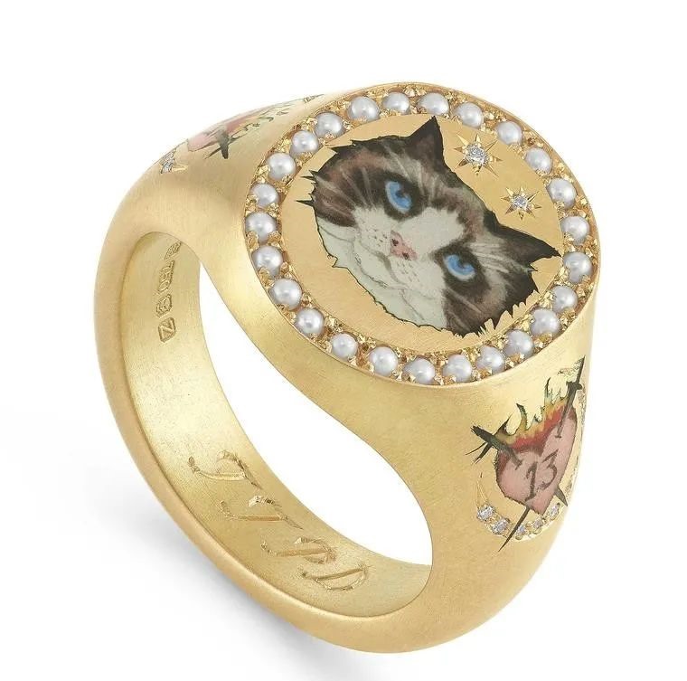 This ring, crafted by Cece Jewellery in London for Taylor Swift, features a design of her cat Benjamin Button in miniature enamel painted on 18k gold.