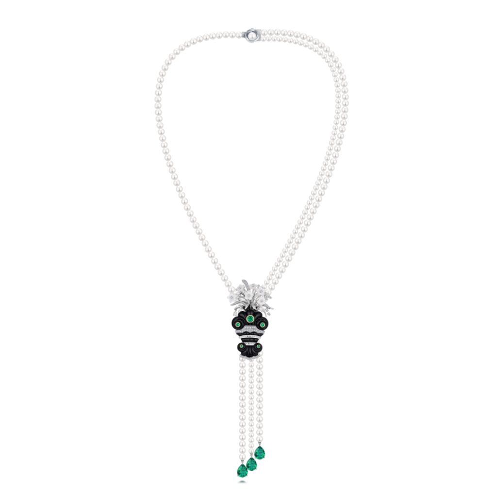 The "Ingenious Linglong Narcissus" white gold necklace by MidnightOperaHouse X Gemfields features pear-shaped and round-cut emeralds, certified to be from Zambia. It is also set with saltwater pearls, black onyx, mother-of-pearl, and diamonds. The piece can be converted into a brooch.