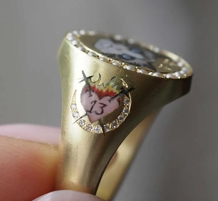 On this highly personalized ring, the number 13 on a burning heart motif represents Taylor Swift's lucky number. All the designs and patterns on the ring are deeply significant to Taylor Swift.