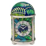 The face of this dome clock is arched with palm leaves and is limited to five pieces. Cloisonné enamel and white enamel are used to create this captivating scene.