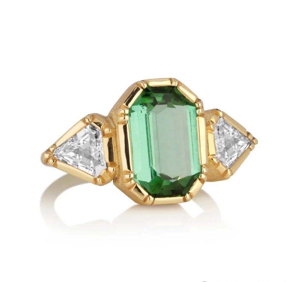 Harmony gold ring, by Brooke Gregson.
The center stone is a 3.49ct emerald-cut green tourmaline, flanked by 2 diamonds.